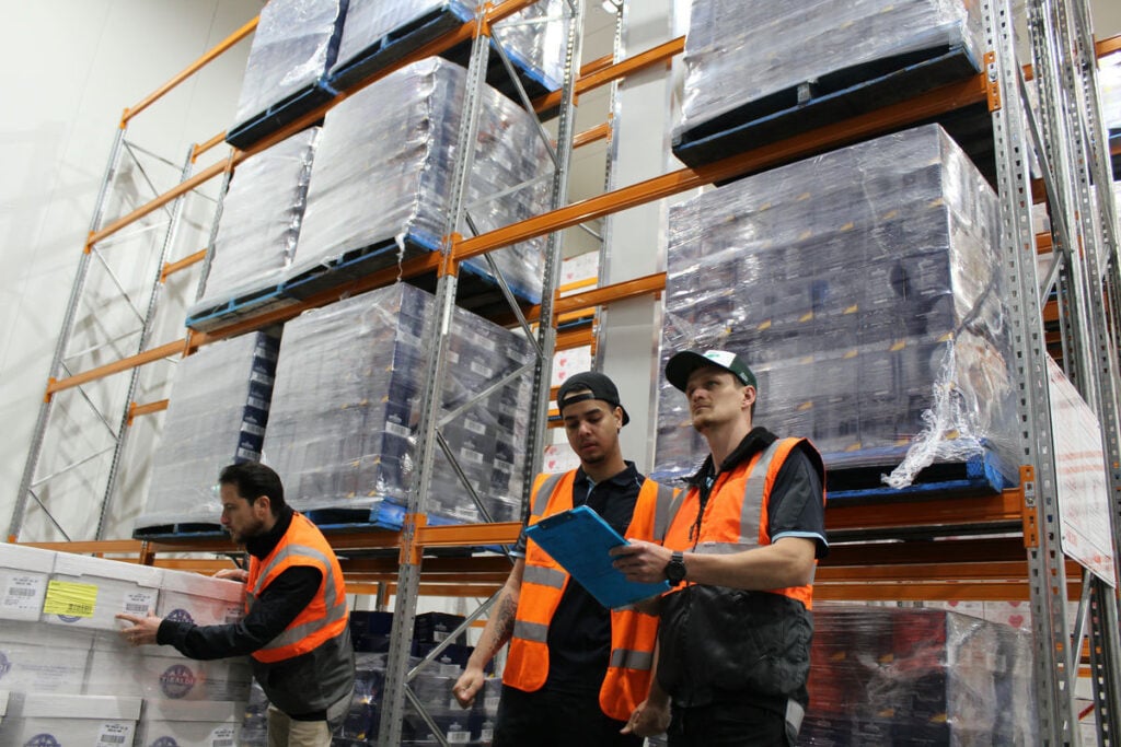Warehouse staff handling pallet shipments for refrigerated transport